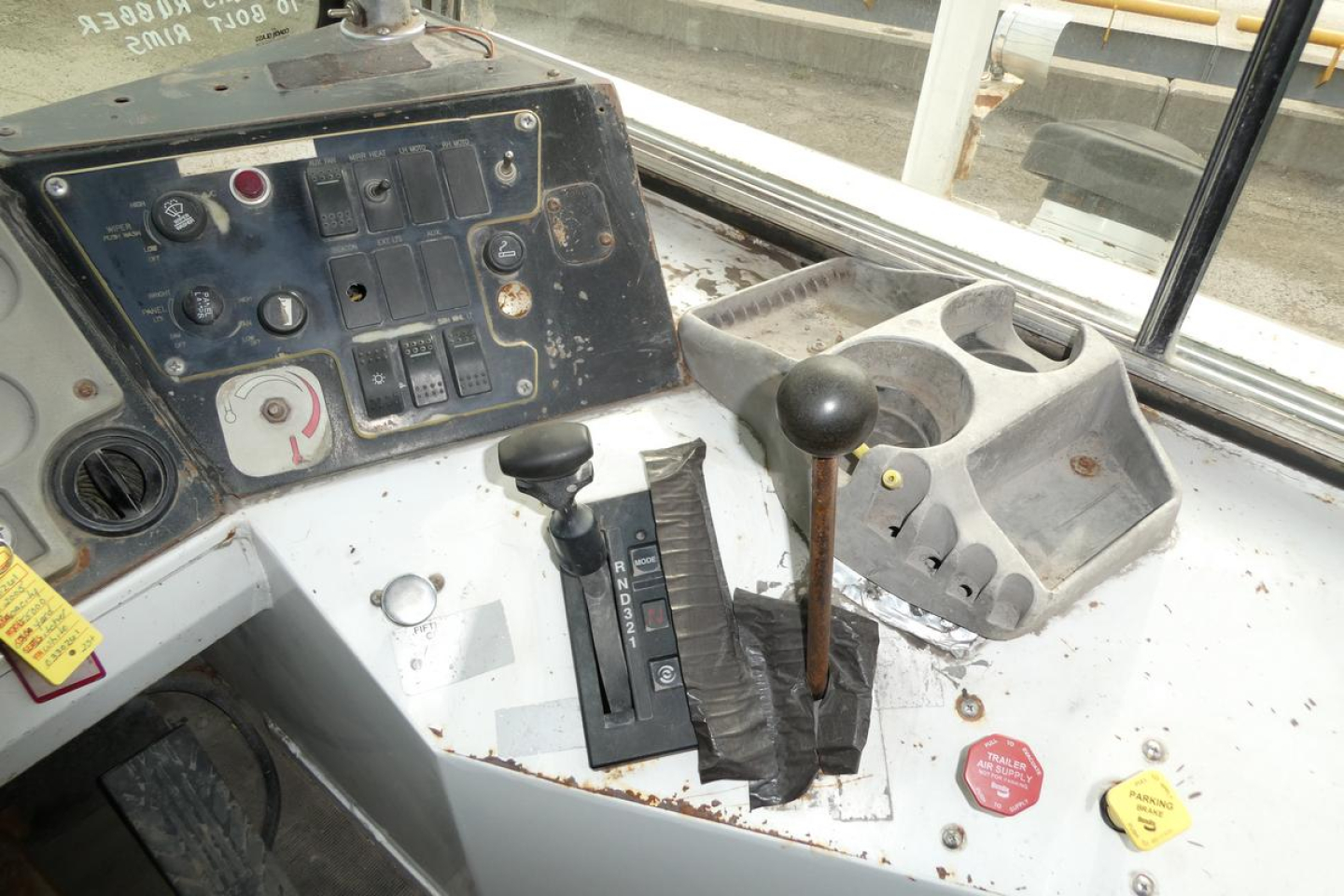 Operator controls in cab showing gear lever and auxiliary switches on dashboard of TJ5000 yard truck.