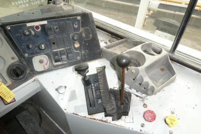 Operator controls in cab showing gear lever and auxiliary switches on dashboard of TJ5000 yard truck.