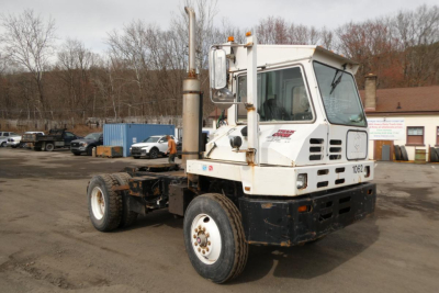 Capacity TJ5000 yard truck chassis with white cab, dual exhaust stacks, and large tires; visible text on cab windows and side panel.