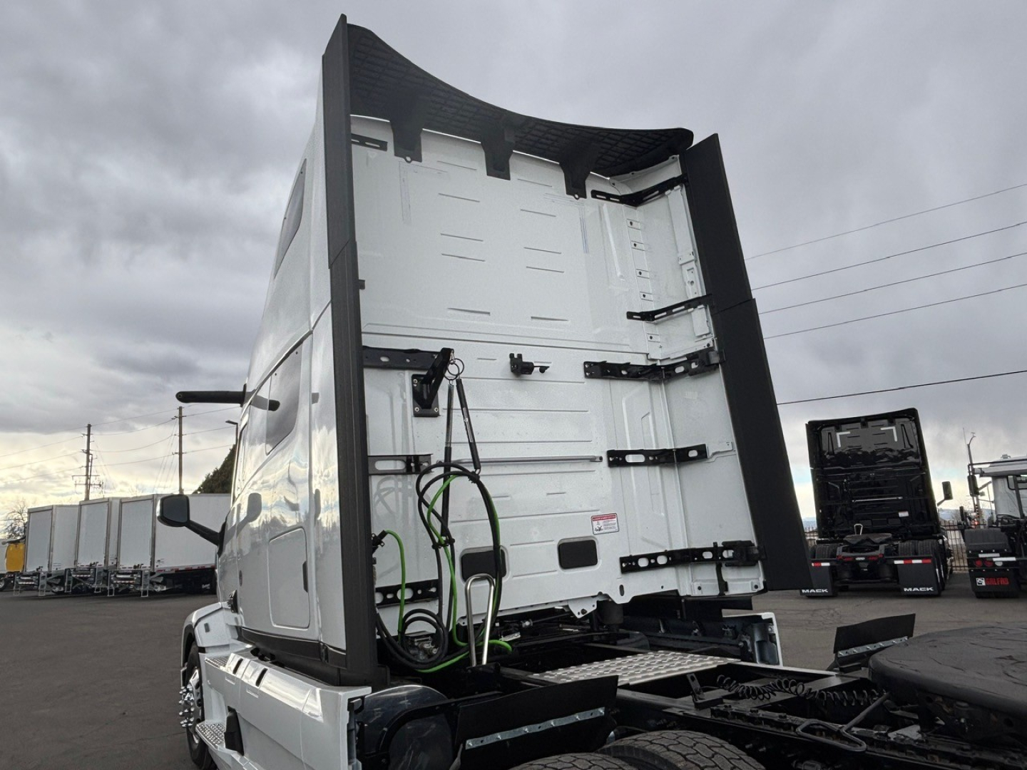 Mack PR64T76H truck cab rear view showing high-roof sleeper, vertical exhaust, and rear doors with latches.