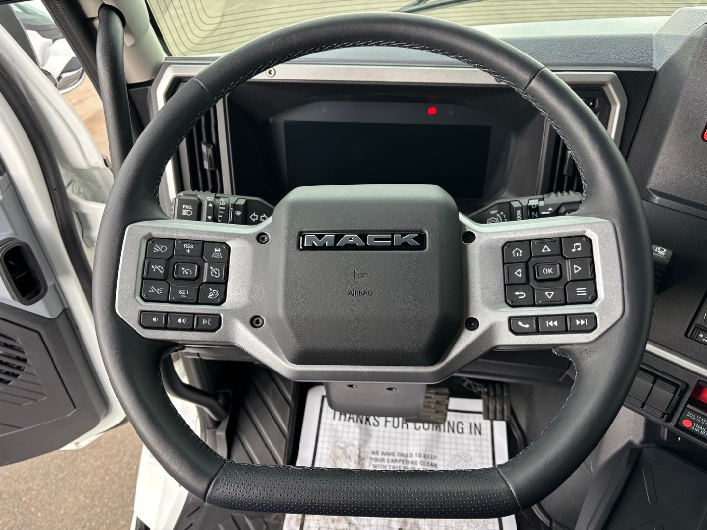 Mack PR64T76H steering wheel and dashboard centered in cab view with control stalks and instrument cluster visible