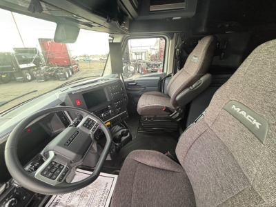 Truck cab interior showing steering wheel, driver seat, and dash of a new 2026 Mack PR64T76H conventional sleeper.