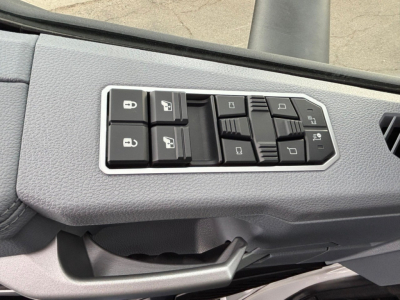 Dashboard controls panel in a Mack PR64T76H showing window/lock switches and mirror controls.