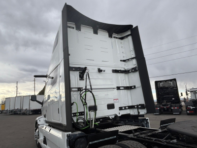 Mack PR64T76H truck cab rear view showing high-roof sleeper, vertical exhaust, and rear doors with latches.
