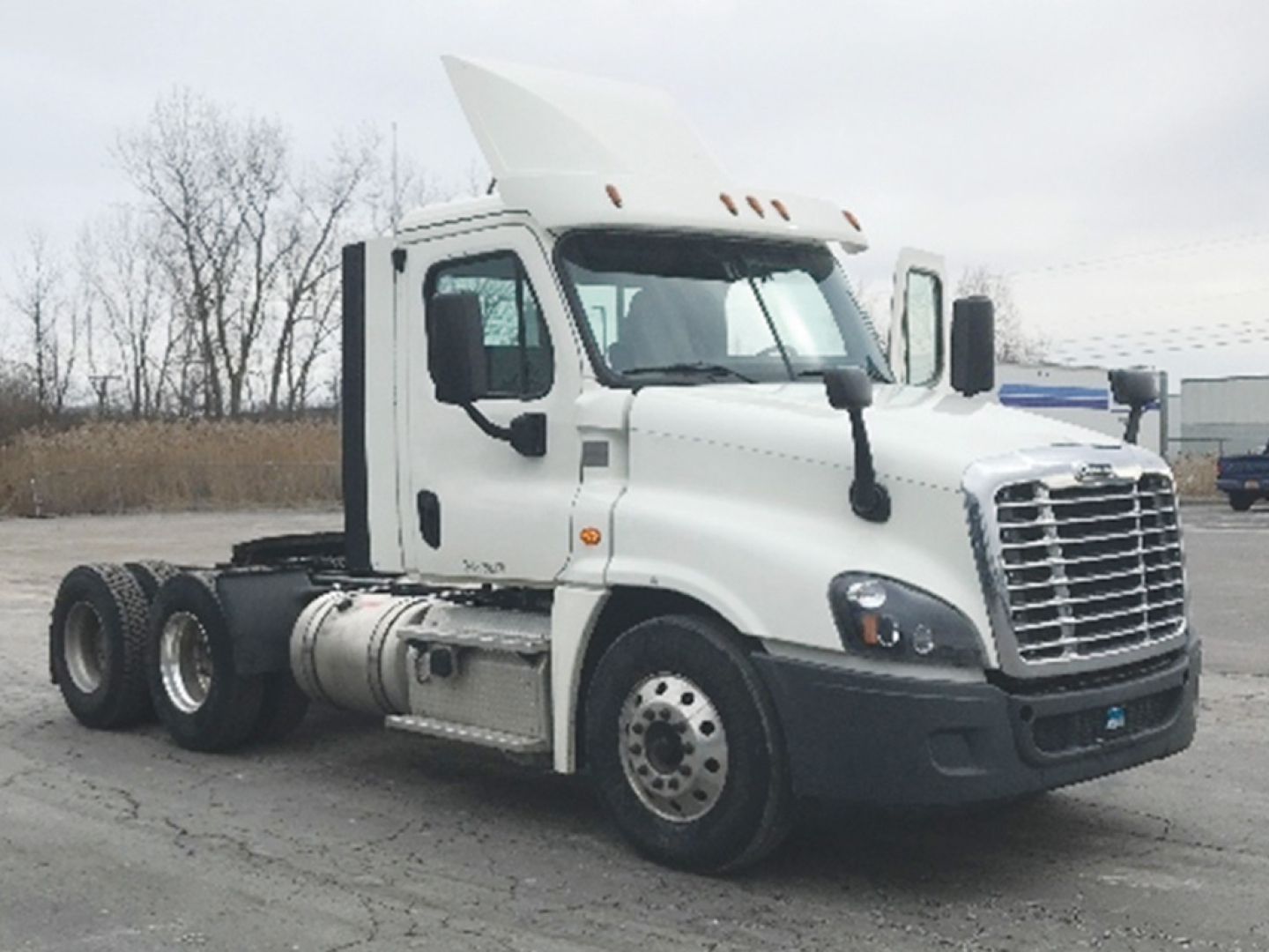 Truck cab and chassis of a 2018 Freightliner Cascadia125 daycab showing Freightliner grill and side mirrors.