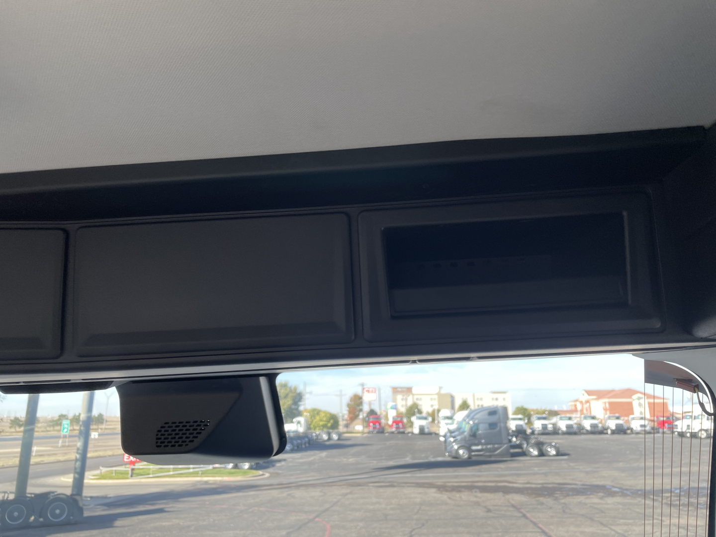 Cab interior area of 2026 Mack PR64T showing overhead dash compartments and window view.