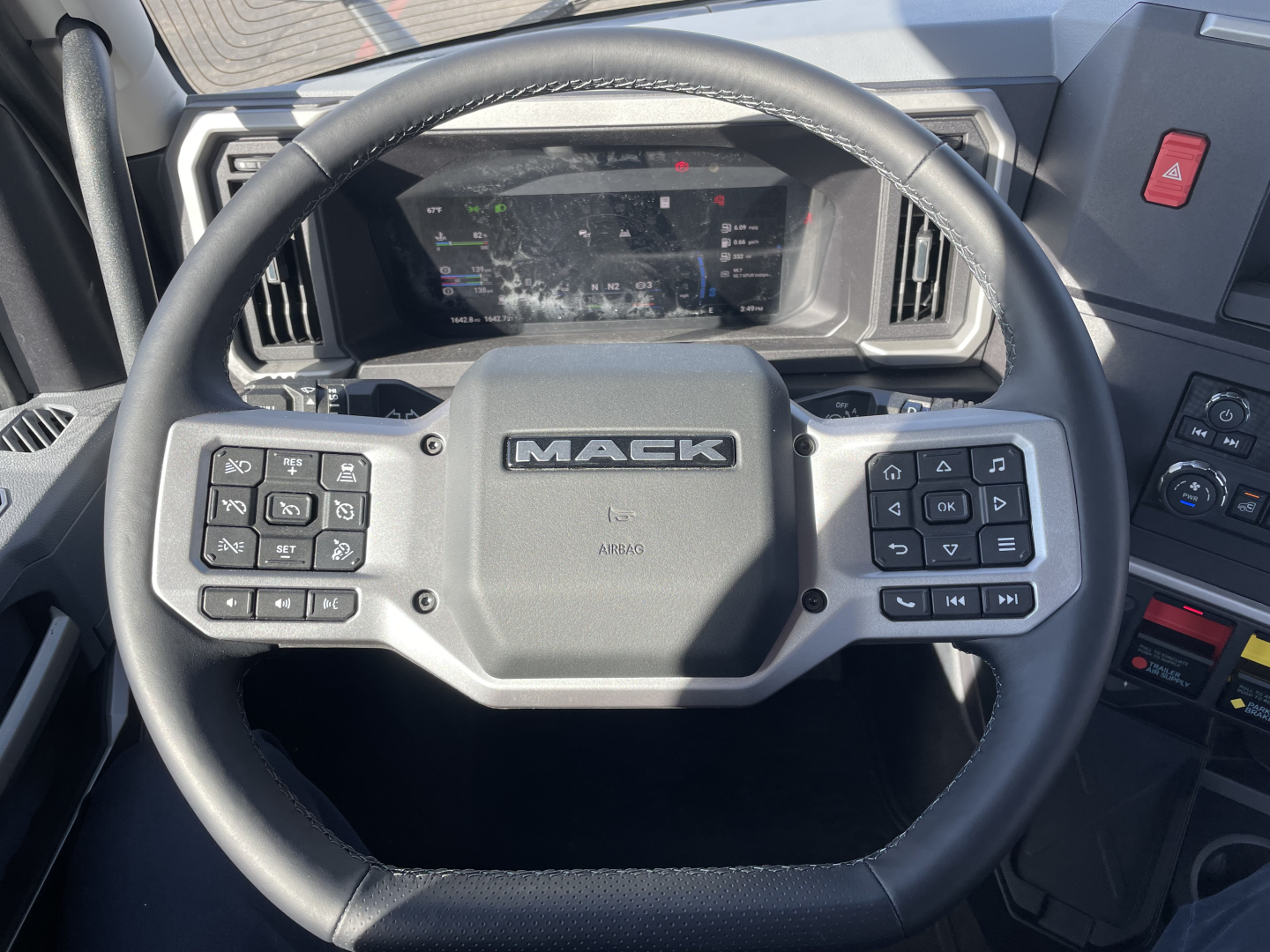 Mack PR64T truck steering wheel and dashboard view with steering wheel branding and instrument cluster visible
