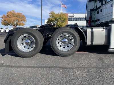 Front-side view of a 2026 Mack PR64T conventional daycab showing dual rear axles and chrome wheels with fuel tank.