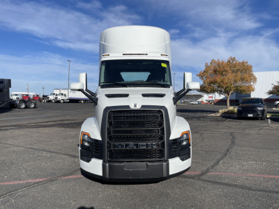 Front view of a white 2026 Mack PR64T truck in a dealership lot, with the large black grille, MACK lettering, and side mirrors visible.
