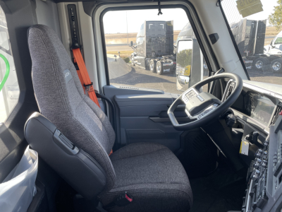 Interior of a 2026 Mack PR64T cab showing steering wheel, driver seat, dashboard, with exterior view through the windshield.