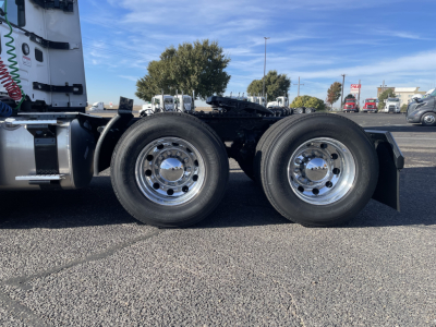 Mack PR64T truck chassis side view showing dual rear axles with polished chrome wheels and tires, cab visible in background.