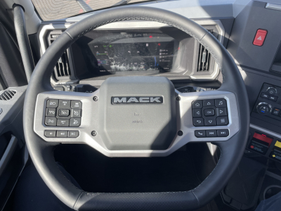 Mack PR64T truck steering wheel and dashboard view with steering wheel branding and instrument cluster visible