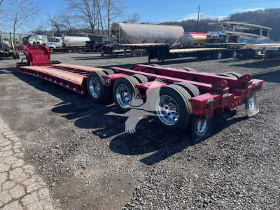 Fontaine 55 Lowboy trailer chassis showing dual rear axles with chrome wheels and red frame.