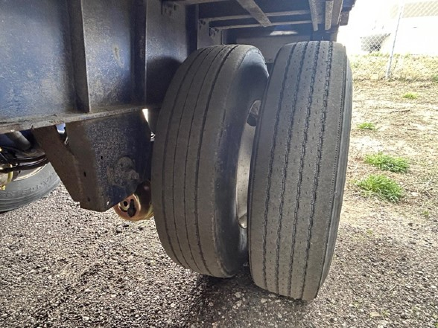 Dual rear wheels on a Great Dane steel spread air flatbed trailer showing tires and undercarriage components.