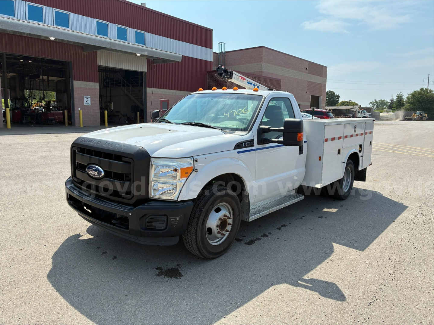 Ford F-350 utility service body pickup truck showing side view with utility bed, white exterior, black grille, and amber clearance lights.