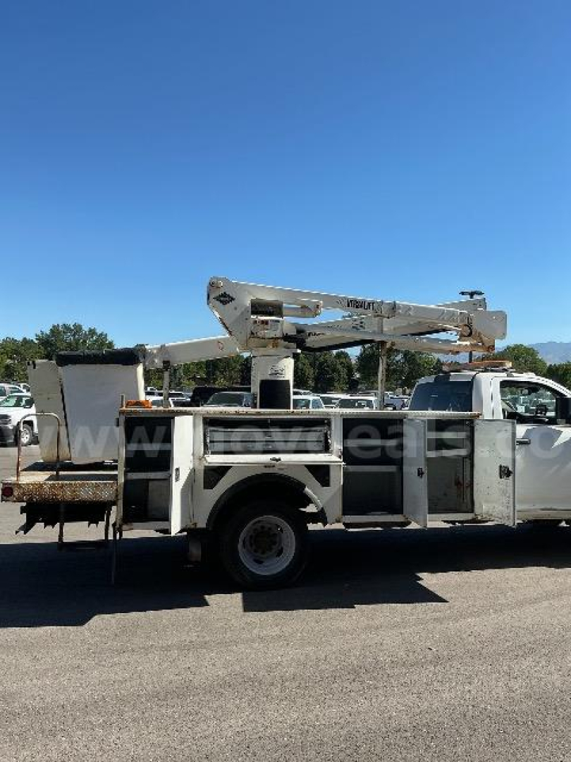 Utility bucket truck body with aerial lift in service panel compartments visible on the side.