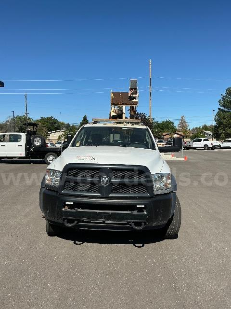 White 2014 Dodge Ram 5500 truck front view in a dealership lot with a bucket attachment overhead.