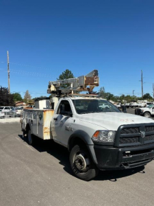 2014 Dodge Ram 5500 bucket truck in a parking lot with crane bucket lift on bed and front bumper guard.