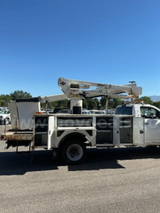 Utility bucket truck body with aerial lift in service panel compartments visible on the side.