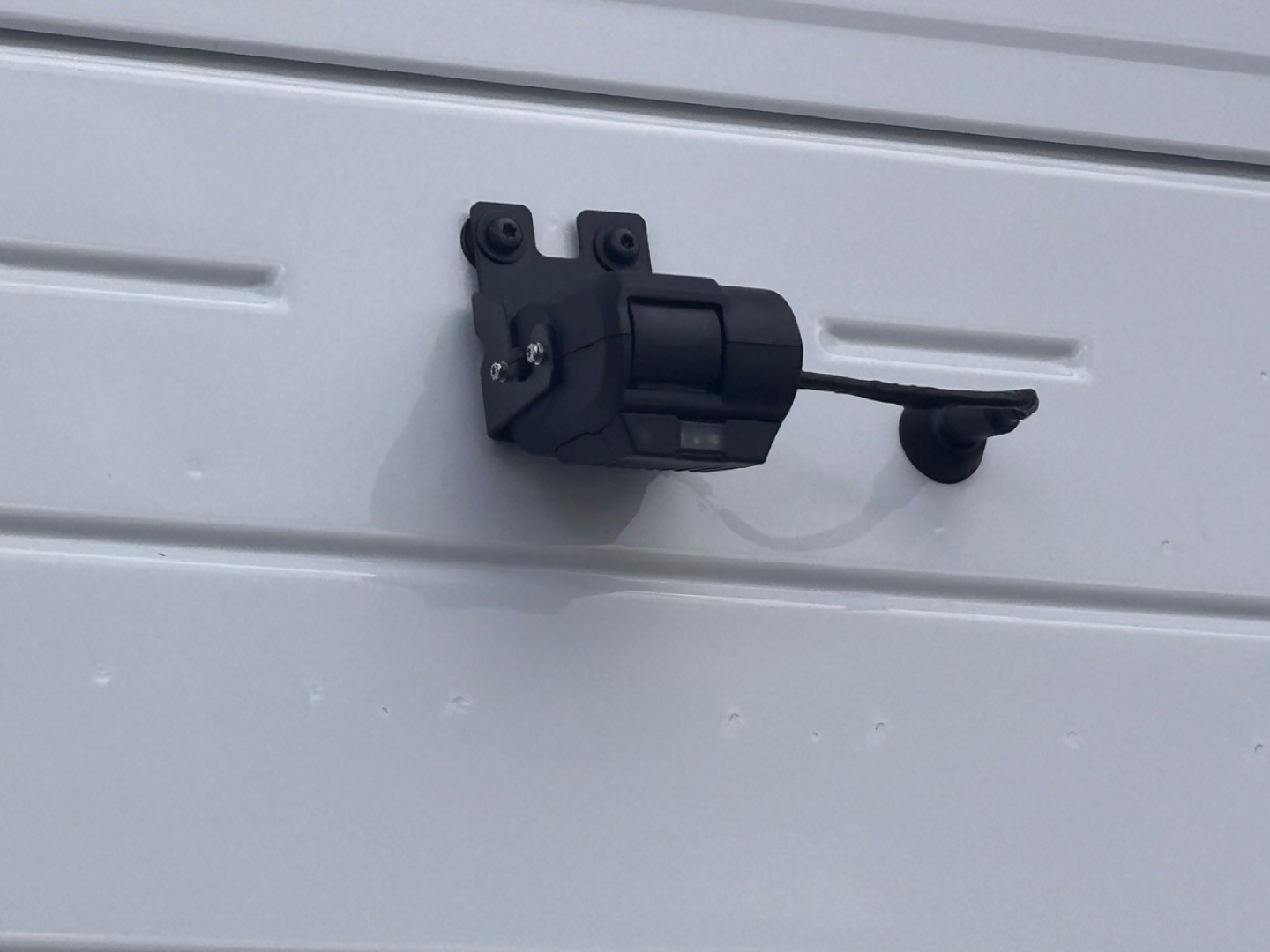 Truck door latch/hinge assembly mounted on a metal surface, view focused on the latch mechanism.