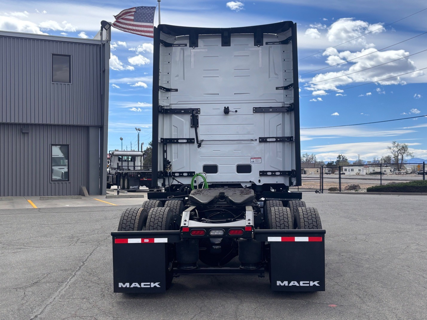Mack PR64T76H tractor rear view showing dual rear axles, mud flaps labeled MACK, and fifth-wheel/drive area with fuel and air lines.