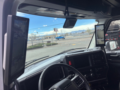 Truck cab interior showing dual side-mounted tablets, dashboard, and rearview mirrors in a 2026 Mack PR64T76H.
