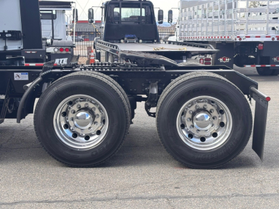 Mack PR64T76H chassis showing dual rear axles with polished wheels and tires, side view.
