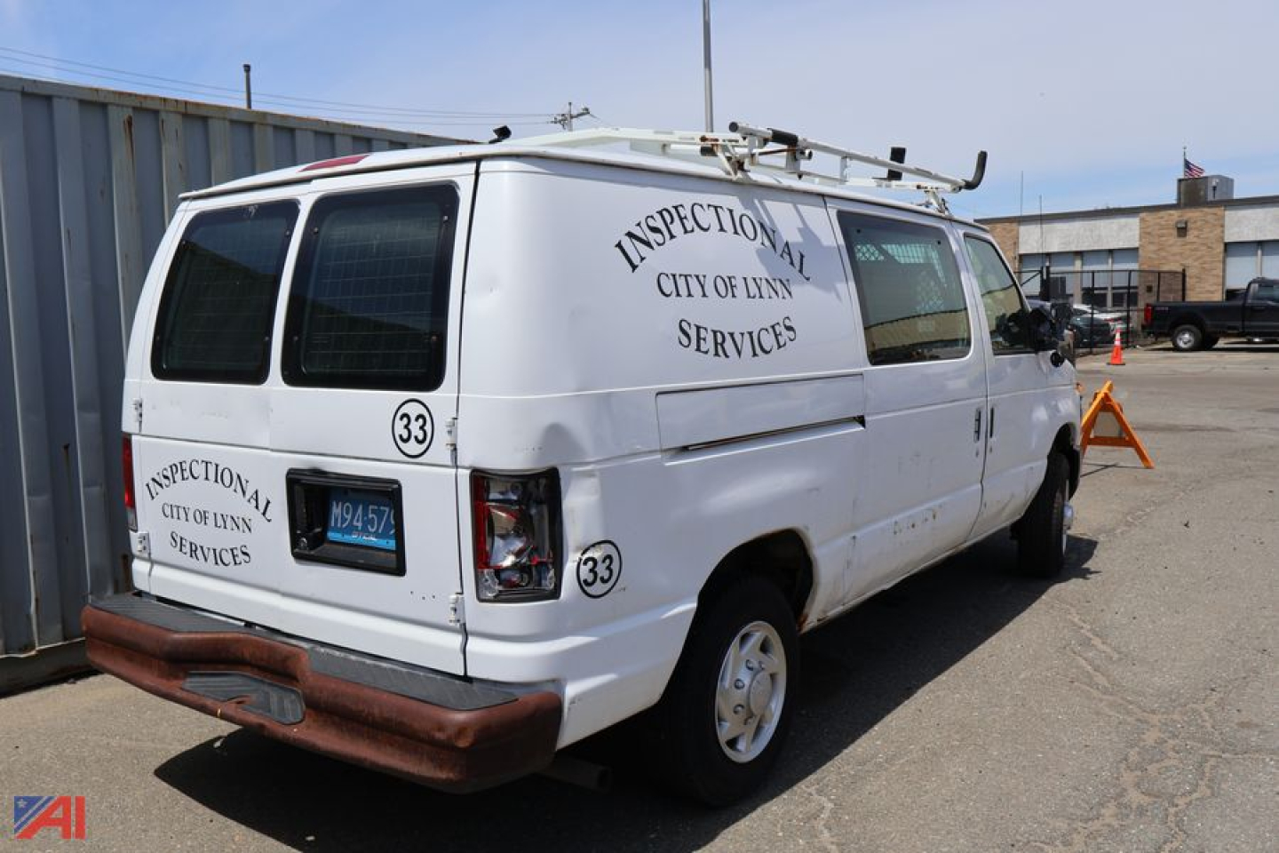 Ford E-150 cargo van with City of Lynn Inspections Services markings, back and side view showing inspection decals and ladder racks.