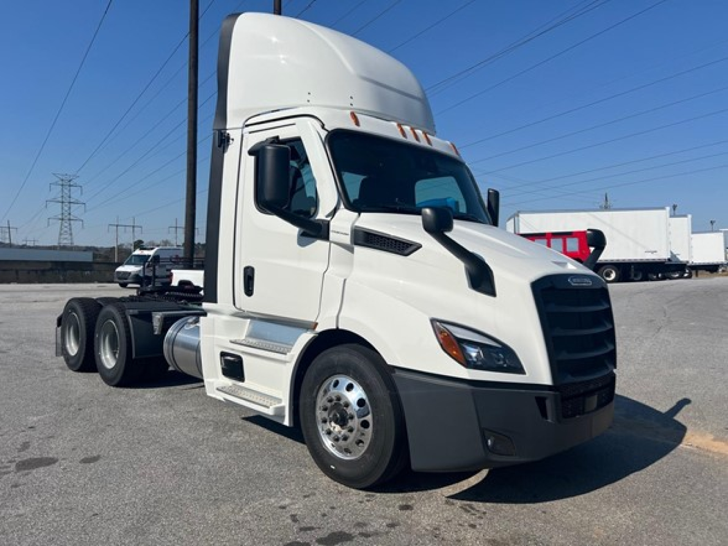 Freightliner Cascadia 116 day cab tractor in white, side view showing cab, front grille, and wheels.