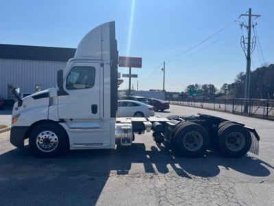 Freightliner Cascadia 116 day cab truck in side profile showing chassis and cab; white exterior with sleeper cab roof fairing and dual rear axles.