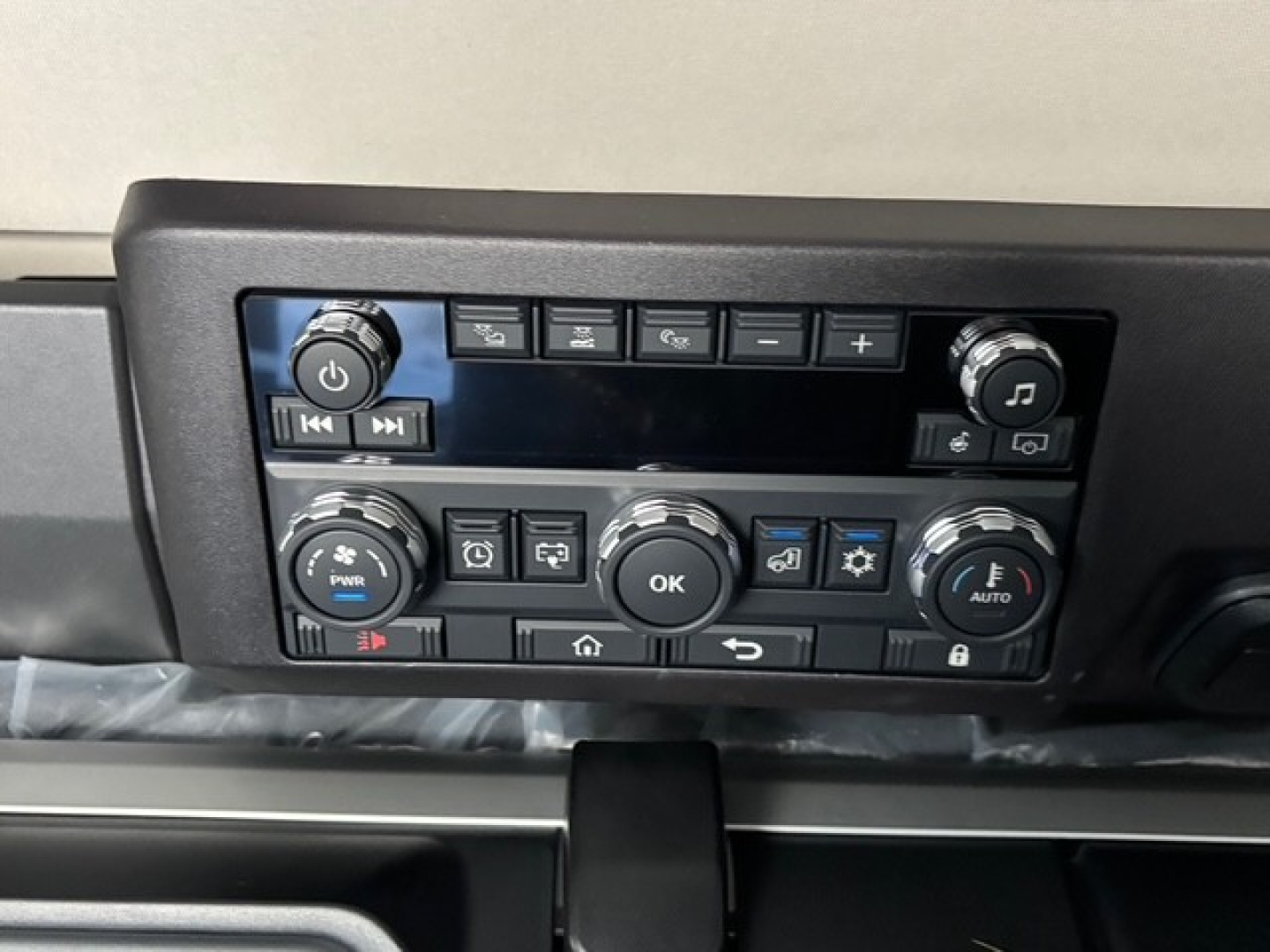 Dashboard control panel of a 2026 Mack PR64T76H truck showing multiple buttons, knobs, and a central display screen.