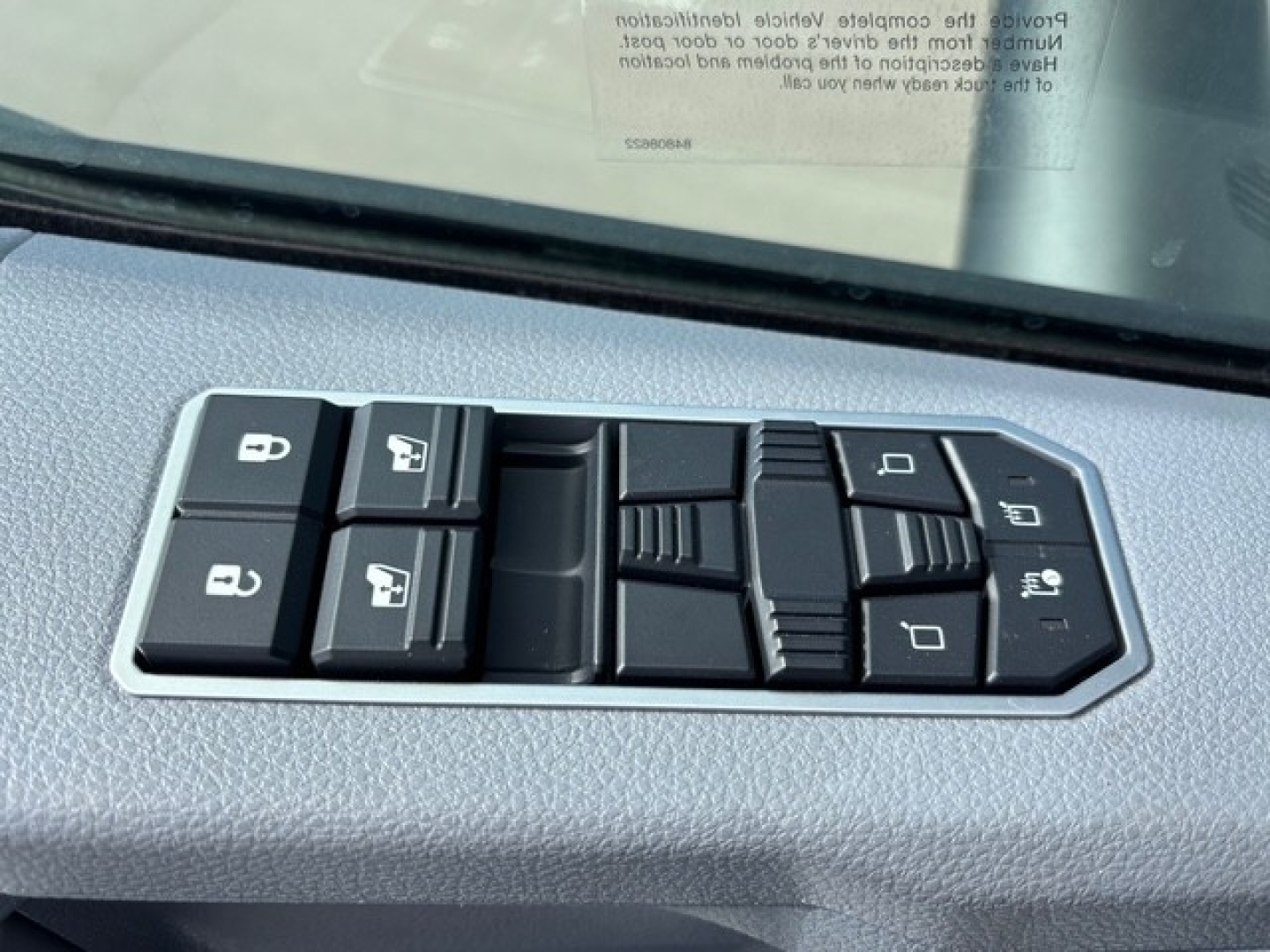 Truck interior door controls cluster with multiple window and lock switches visible in the driver's door panel.