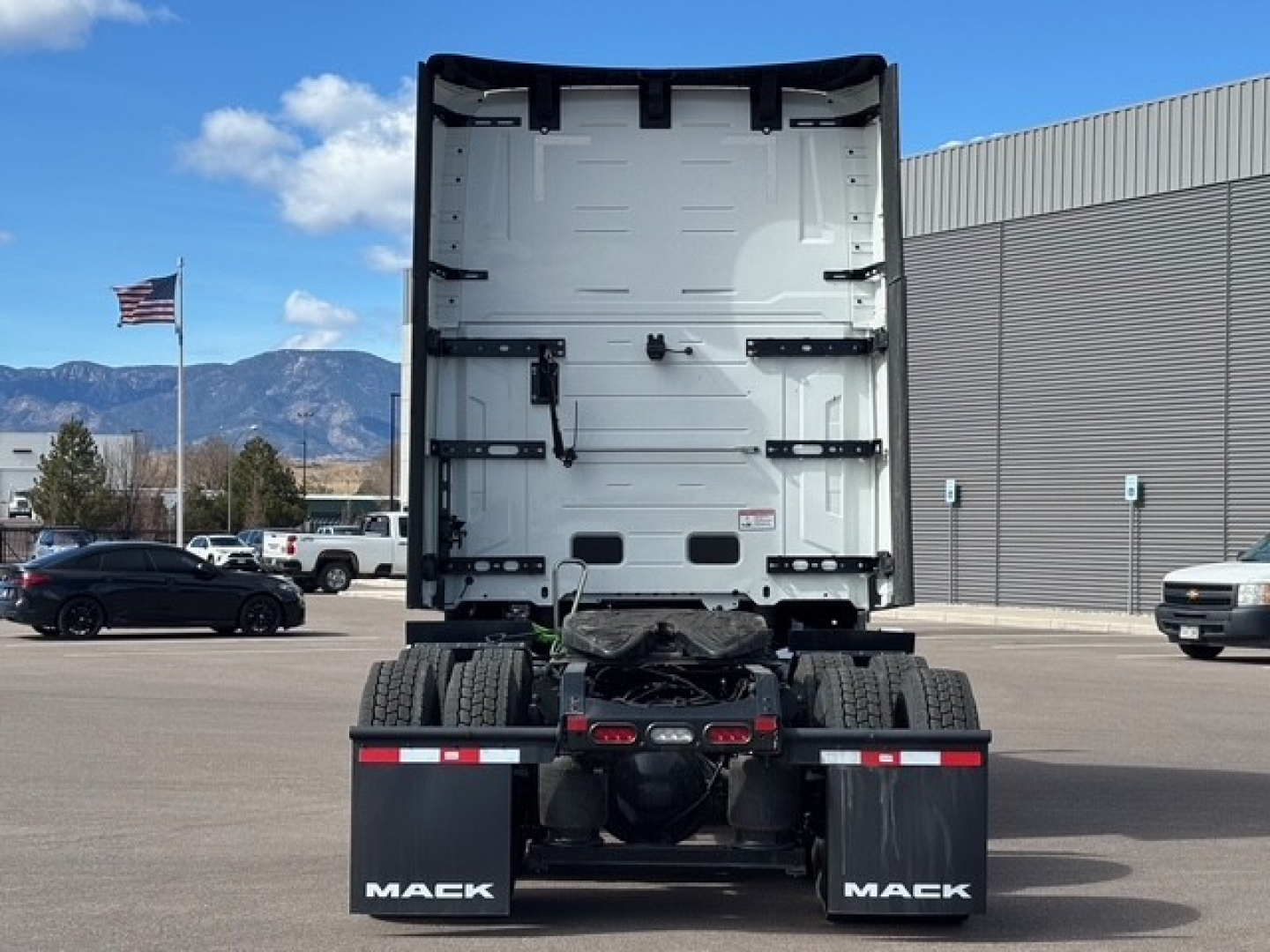 Rear view of a Mack PR64T76H truck tractor showing the fifth wheel area and dual rear axles with Mack branding on mudflaps.