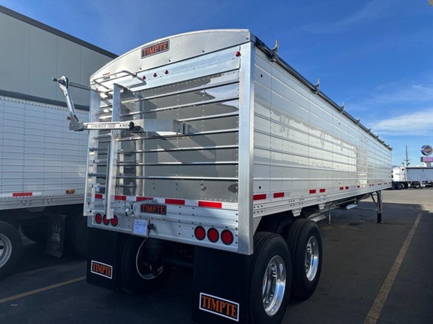 Timpte Super Hopper trailer showing rear view with tandem axles and aluminum side panels.