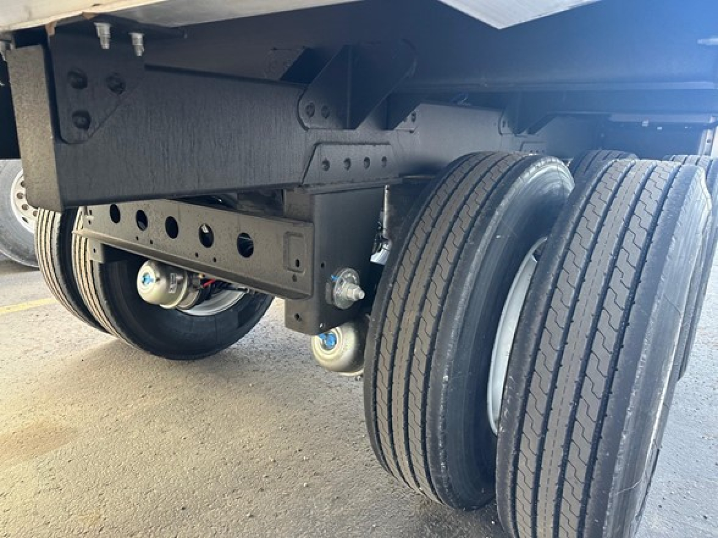 Trailer underside showing dual rear axles and suspension components of a Timpte hopper trailer.