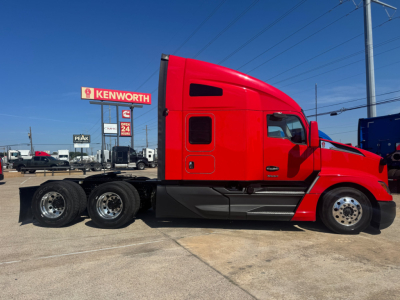 Kenworth T680 side view showing cab and chassis with red paint, stock number 0631148, VIN 1XKYD49X2PJ230596, and Kenworth signage in background.
