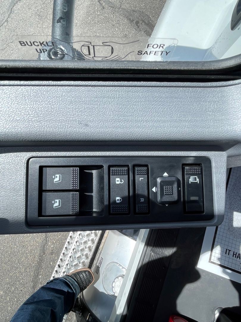 Mack MD6 cockpit control panel with window and mirror controls and push buttons visible.
