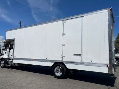 Box truck side view showing cargo box and cab of a 2025 Mack MD6 with VIN plate partially visible; no legible model text visible on image.