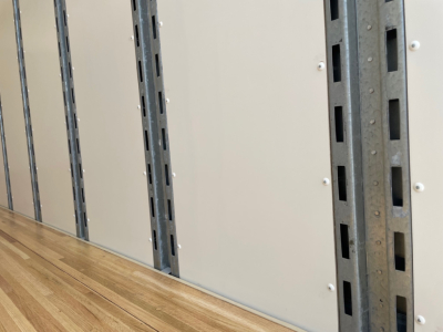 No engine or cab visible; interior truck trailer wall with vertical metal rails and plywood floor sections.