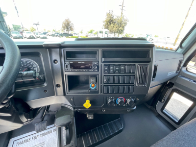 Mack MD6 cockpit dashboard showing instrument cluster, radio, control switches, and HVAC knobs.