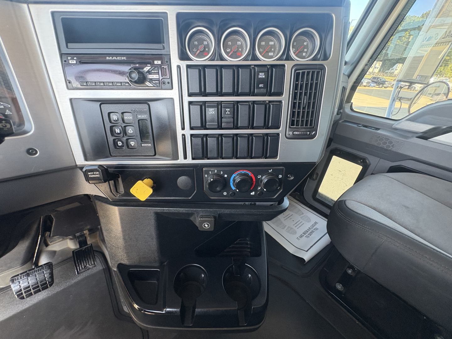 Dashboard of a 2021 Mack GR64F truck showing instrument cluster, control switches, and climate controls in center console.