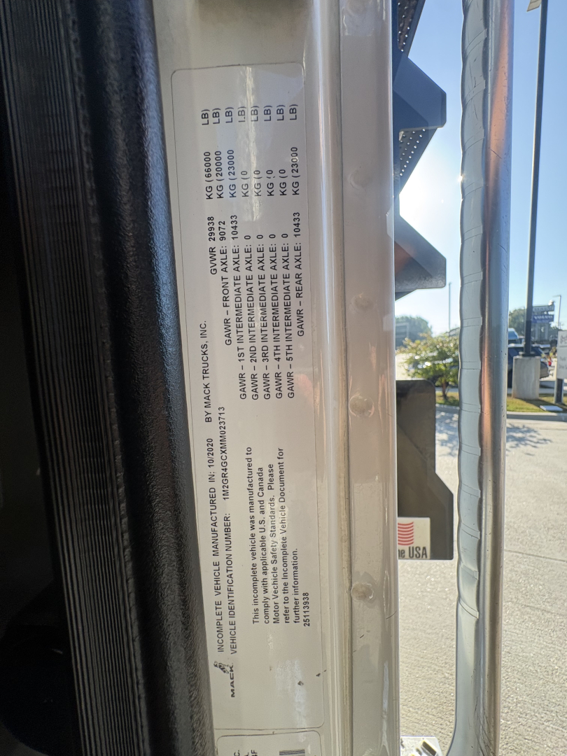 Label on truck door with specification codes and weights. Vertical plate shows various codes and numbers, likely chassis/engine specs and capacities.