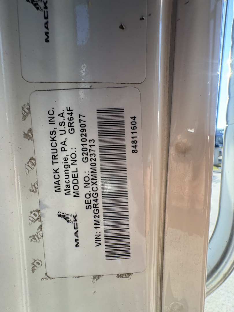 Mack label on truck door with model info: 'MACK TRUCKS, INC. MAC... MODEL GR64F' and VIN 1M2GR4GCXMM023713; barcode and serial numbers visible.