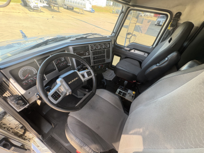 Mack GR64F truck cabin interior showing steering wheel, gauge cluster, and driver seat with center console.