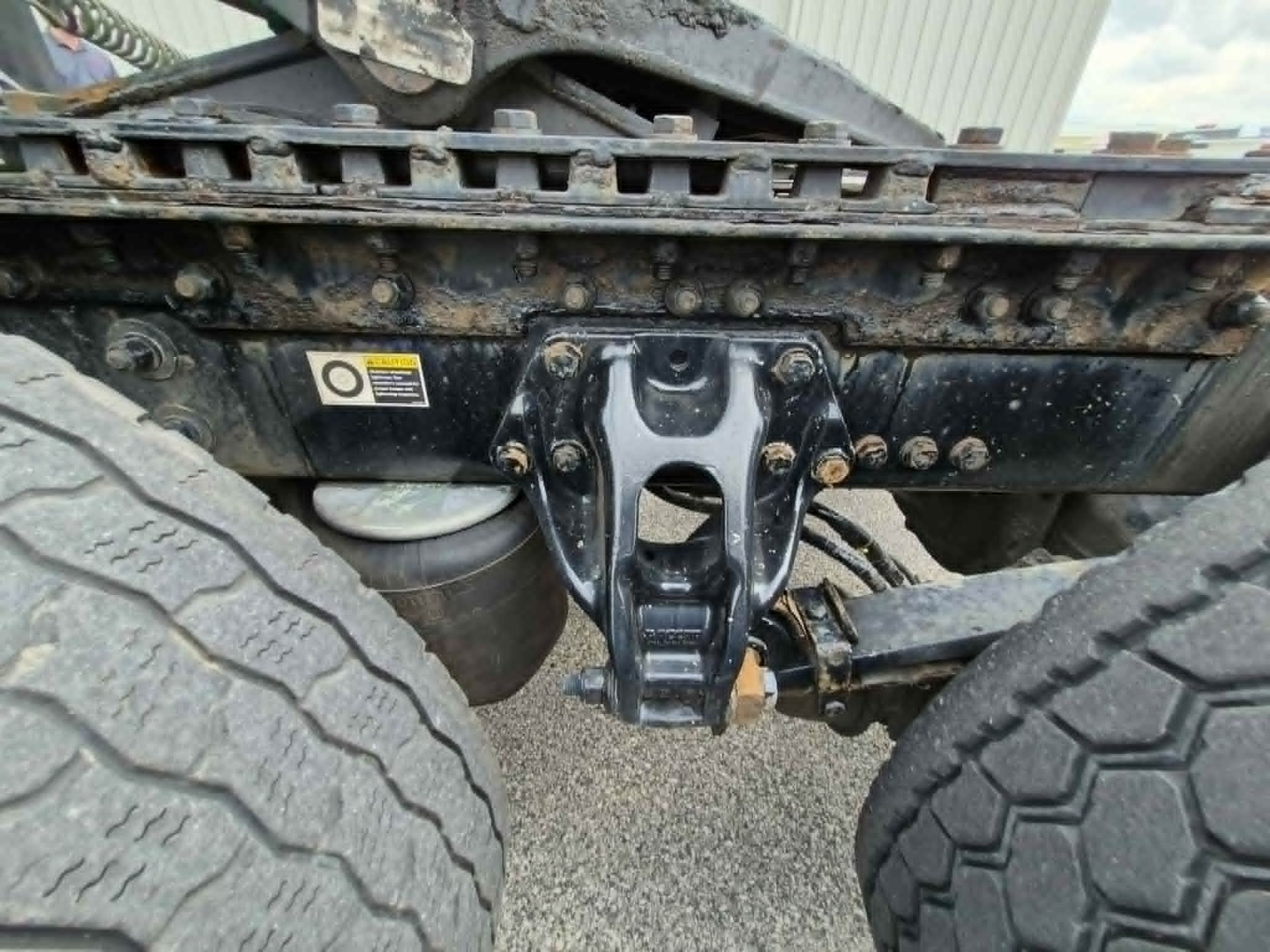 Kenworth T680 chassis rear view showing fifth wheel hitch and dual rear tires with undercarriage and frame components.