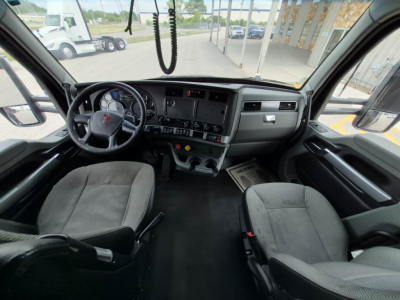 Kenworth T680 truck cab interior with steering wheel, dashboard, and two seats visible.
