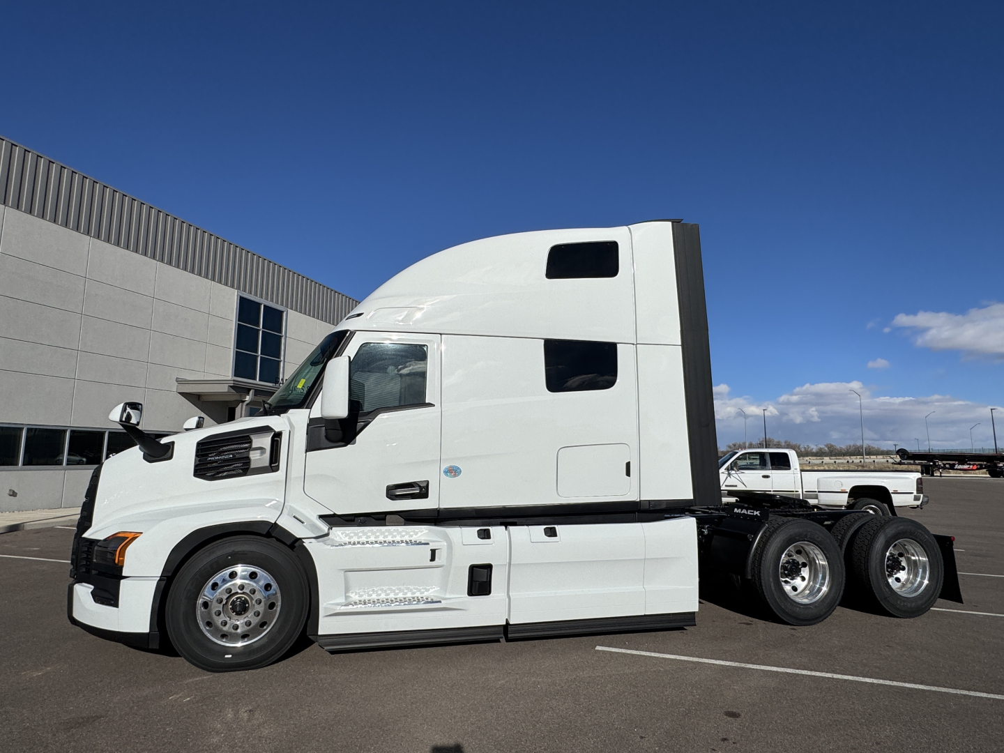 Mack PR64T76H conventional sleeper tractor in white, side view showing cab and dual rear axles.