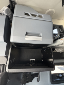 Mack PR64T76H cab interior showing center console open with storage bin and cup holder area visible.
