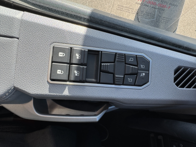 Truck interior door control panel with window and lock switches visible.