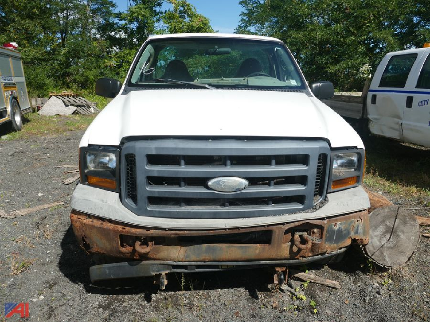 Front view of a white 2006 Ford F-350 Super Duty single rear wheel pickup with a rusted front bumper, grille, and headlights visible.